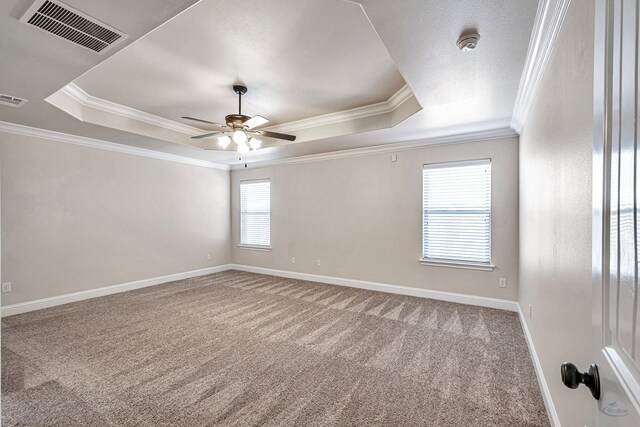 unfurnished room featuring carpet floors, a tray ceiling, and crown molding