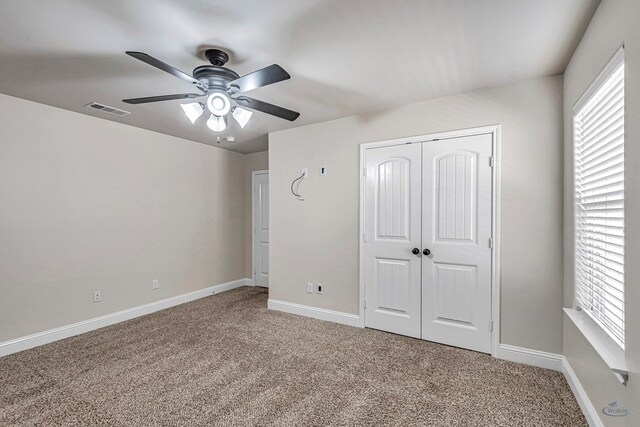 unfurnished bedroom featuring carpet flooring, a closet, and ceiling fan