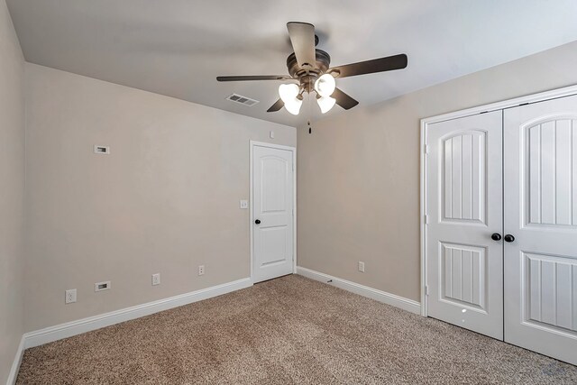 unfurnished bedroom featuring ceiling fan, light carpet, and a closet