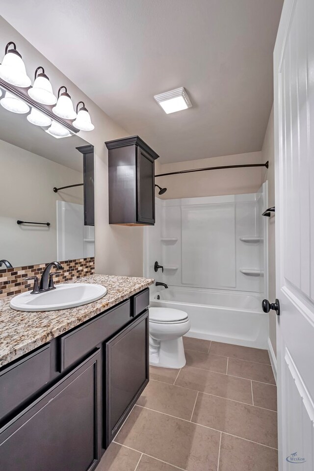 full bathroom featuring washtub / shower combination, vanity, backsplash, and tile patterned flooring