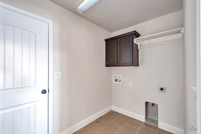 washroom with tile patterned floors, hookup for an electric dryer, cabinets, and washer hookup