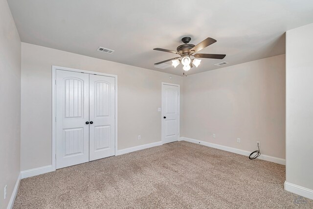 unfurnished bedroom featuring ceiling fan, light carpet, and a closet