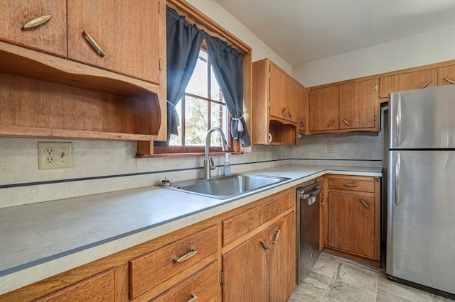 kitchen with a sink, brown cabinets, stainless steel appliances, and light countertops