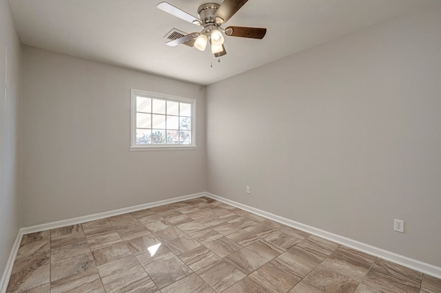 spare room with visible vents, a ceiling fan, and baseboards