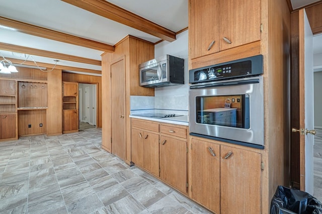 kitchen with beam ceiling, stainless steel appliances, light countertops, brown cabinetry, and wooden walls