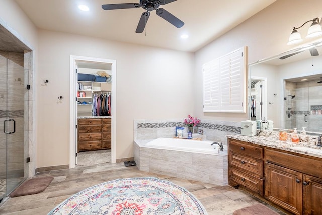 7311 E County Rd 112, Midland, TX 79706 - full bath with a ceiling fan, vanity, a shower stall, a garden tub, and recessed lighting