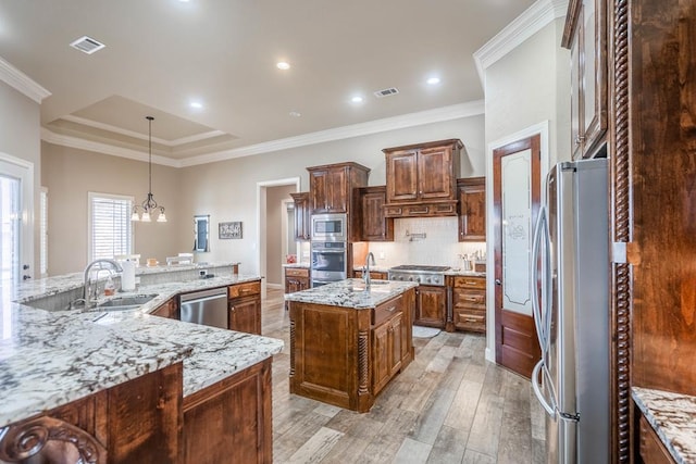7311 E County Rd 112, Midland, TX 79706 - kitchen featuring stainless steel appliances, a large island, a sink, light wood-style flooring, and decorative backsplash