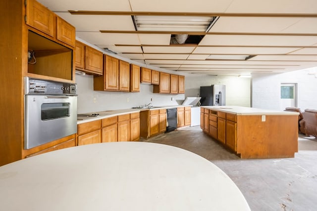 kitchen featuring black appliances, concrete flooring, and a kitchen island