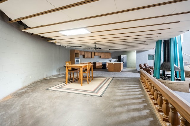 basement featuring stainless steel fridge with ice dispenser