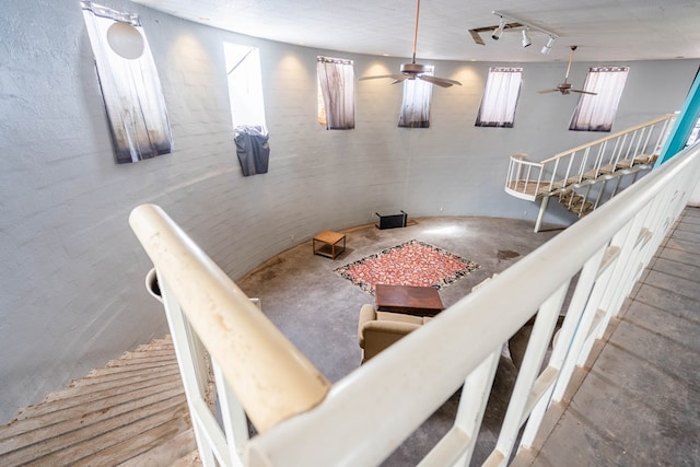 interior space featuring ceiling fan, concrete floors, and track lighting