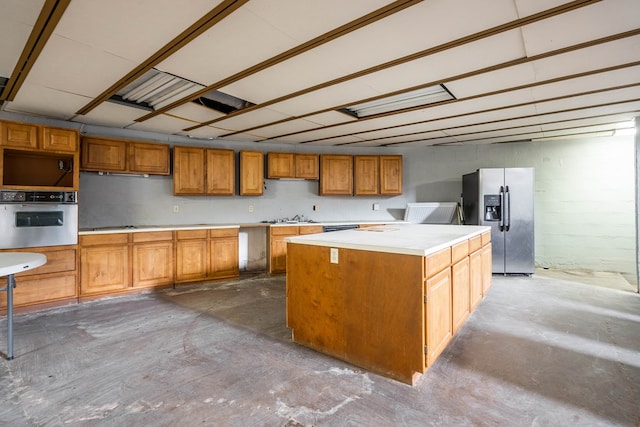 kitchen featuring appliances with stainless steel finishes, concrete floors, and a center island