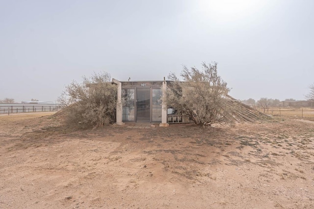 back of property featuring an outbuilding and a rural view