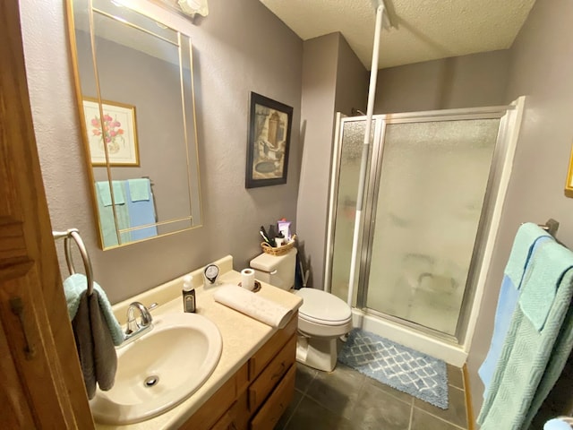 bathroom with tile patterned flooring, an enclosed shower, a textured ceiling, toilet, and vanity