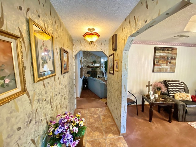 hallway featuring light carpet and a textured ceiling