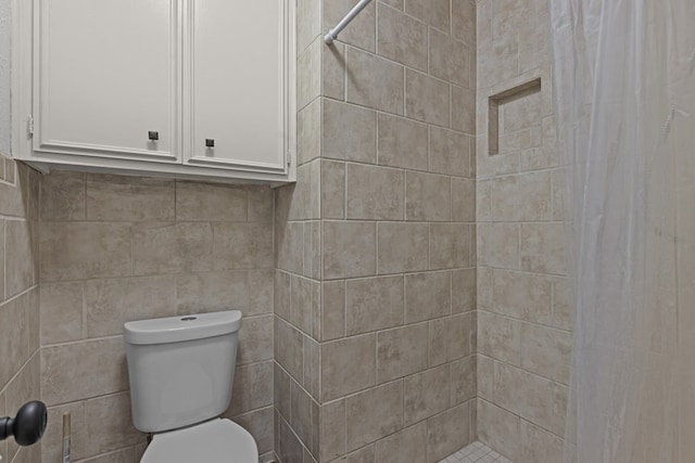 bathroom featuring toilet, tile walls, and walk in shower