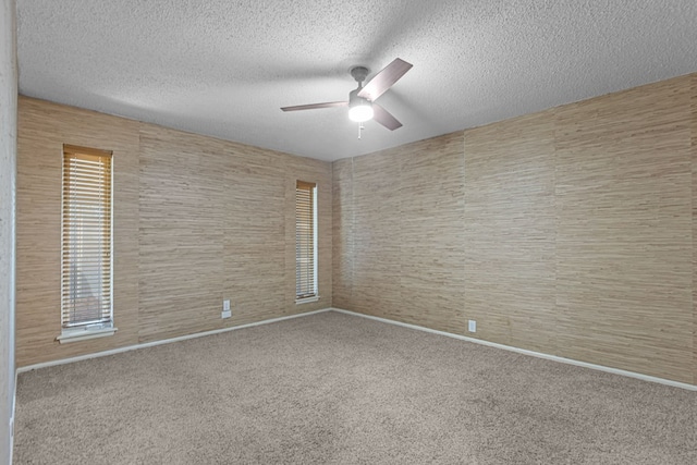 carpeted spare room featuring a textured ceiling and ceiling fan