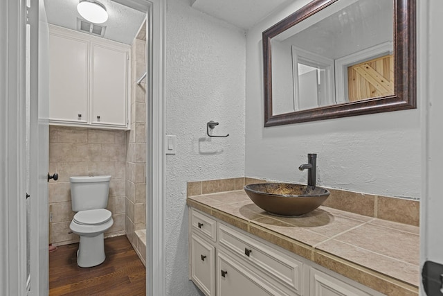 bathroom with vanity, hardwood / wood-style floors, tile walls, and toilet