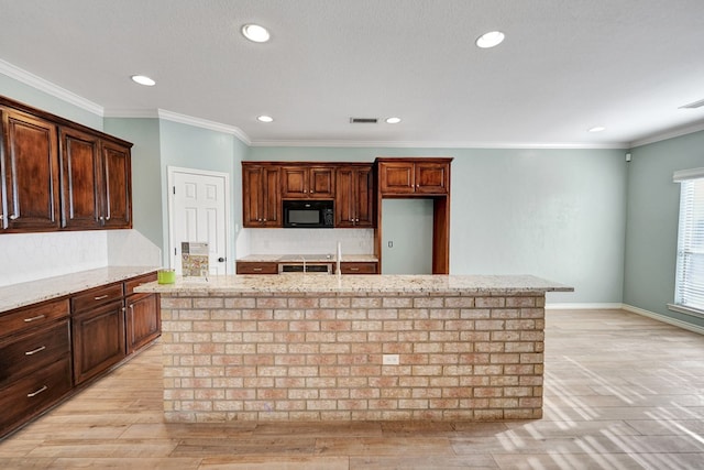 kitchen featuring decorative backsplash, ornamental molding, light stone countertops, and a kitchen island