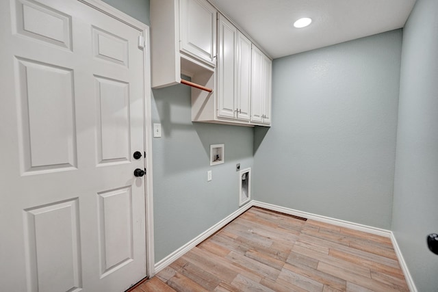 laundry area with electric dryer hookup, hookup for a washing machine, light hardwood / wood-style floors, and cabinets