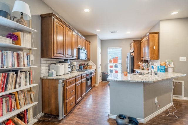 3505 Coquina Ln, Midland, TX 79707 - kitchen featuring dark wood-style floors, light stone counters, a peninsula, decorative backsplash, and recessed lighting
