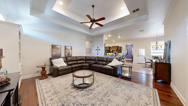 living room featuring arched walkways, visible vents, ornamental molding, and ceiling fan with notable chandelier
