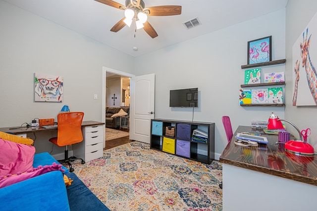 office featuring visible vents, a ceiling fan, baseboards, and wood finished floors