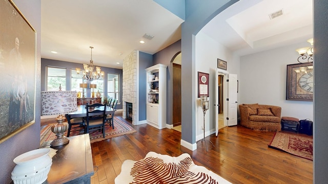 interior space featuring wood-type flooring, visible vents, recessed lighting, a chandelier, and arched walkways