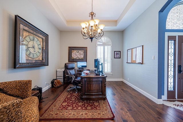office space with arched walkways, baseboards, dark wood-style floors, a notable chandelier, and a tray ceiling