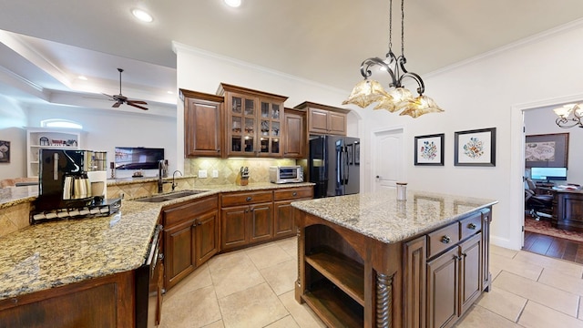 kitchen with decorative backsplash, a sink, light tile patterned floors, freestanding refrigerator, and ceiling fan with notable chandelier
