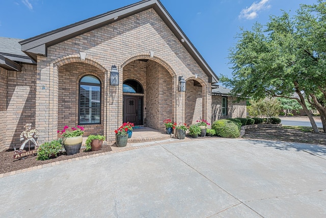 view of exterior entry with brick siding