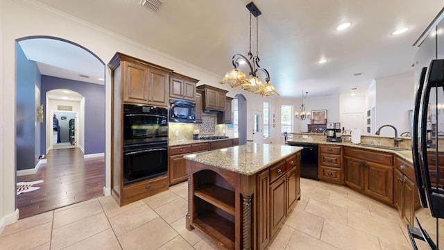 kitchen with arched walkways, an inviting chandelier, a sink, and black appliances