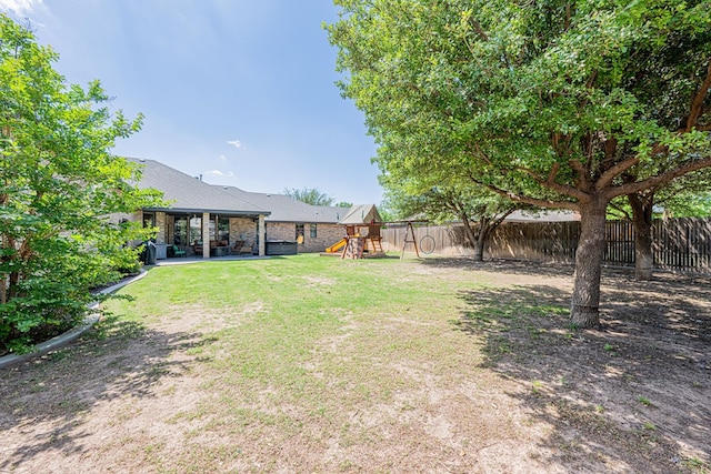 view of yard with a patio, a fenced backyard, and a playground