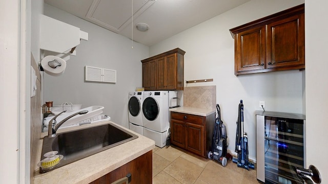 laundry area featuring washer and dryer, beverage cooler, attic access, a sink, and cabinet space