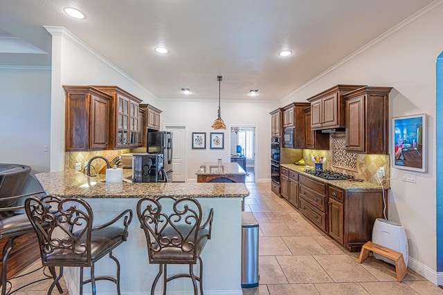kitchen featuring ornamental molding, a peninsula, a kitchen breakfast bar, light stone counters, and black appliances