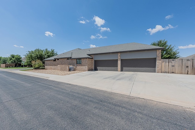 view of front facade featuring fence, driveway, and brick siding