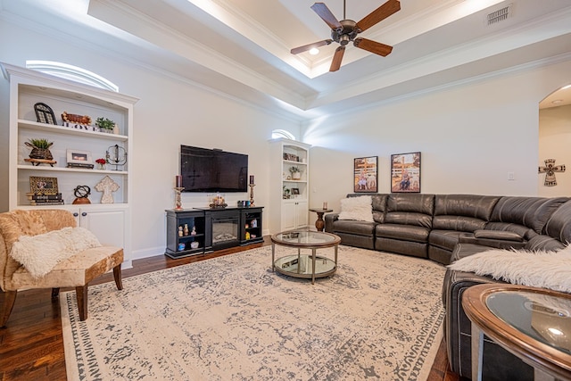 living area with visible vents, crown molding, ceiling fan, dark wood-style floors, and arched walkways