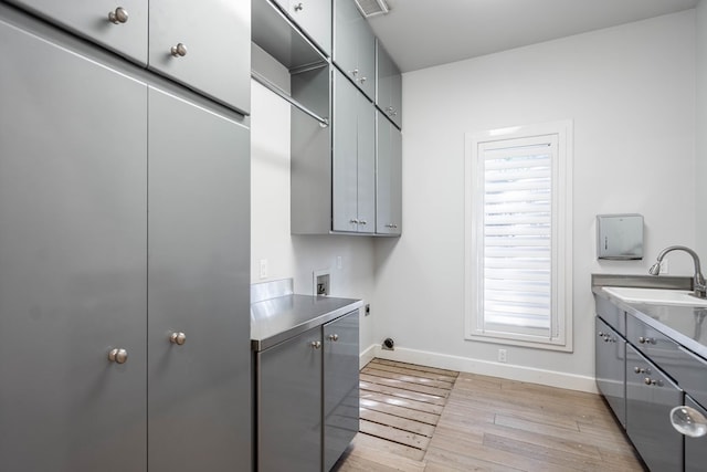 15 Lakes Dr, Midland, TX 79705 - laundry room featuring cabinet space, hookup for an electric dryer, light wood-style flooring, washer hookup, and healthy amount of natural light