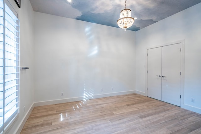 15 Lakes Dr, Midland, TX 79705 - empty room with healthy amount of natural light, light wood finished floors, and a chandelier
