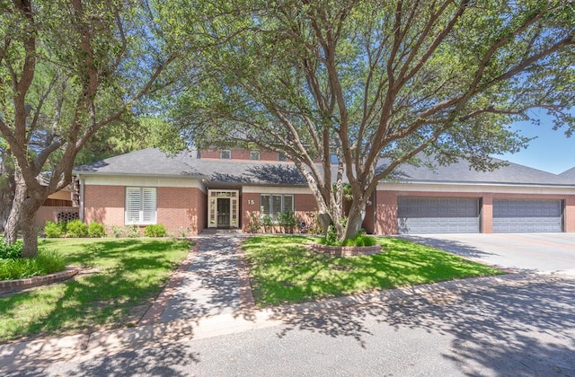 15 Lakes Dr, Midland, TX 79705 - view of front facade featuring brick siding, driveway, a front lawn, and an attached garage