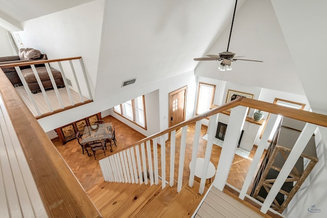 stairway featuring high vaulted ceiling and ceiling fan