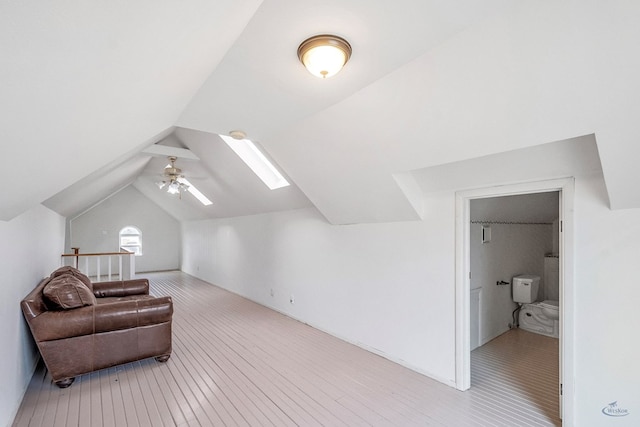 interior space with ceiling fan and vaulted ceiling with skylight