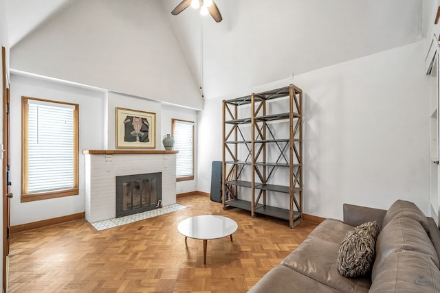 living room featuring ceiling fan, a fireplace, light parquet flooring, and high vaulted ceiling