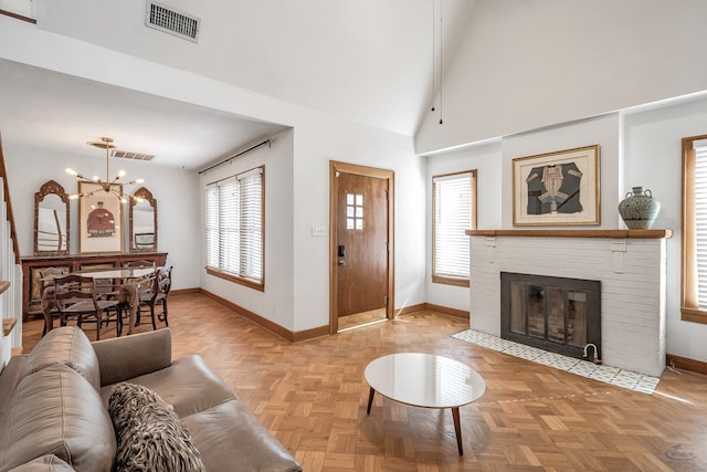 living room with lofted ceiling with beams, a fireplace, an inviting chandelier, and light parquet floors