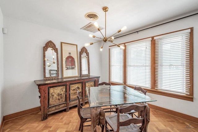 dining space with light parquet flooring and a chandelier