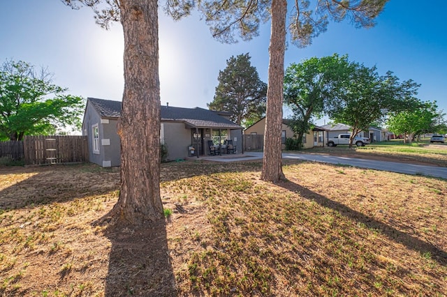 view of front facade with fence, stucco siding, and aphalt driveway