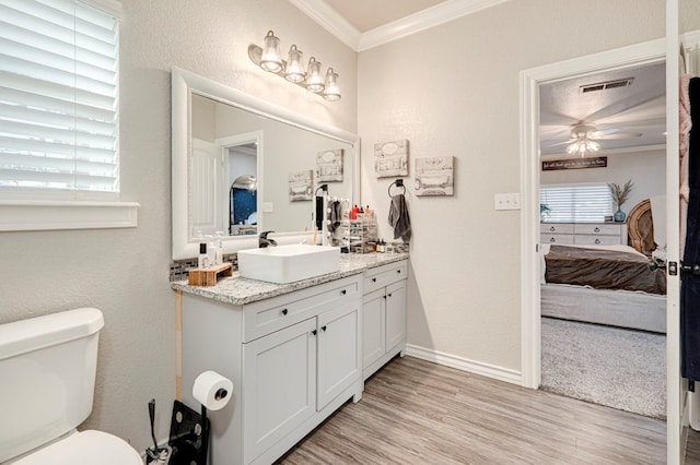 ensuite bathroom with vanity, ensuite bath, toilet, wood finished floors, and ornamental molding