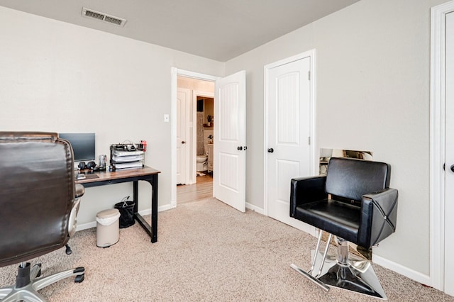 carpeted office space with baseboards and visible vents