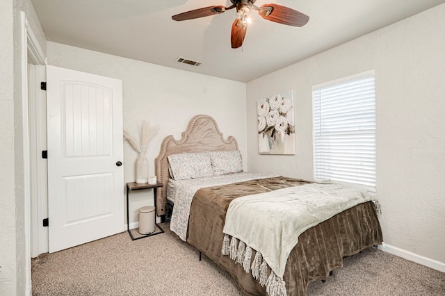 bedroom featuring baseboards, visible vents, light carpet, and ceiling fan