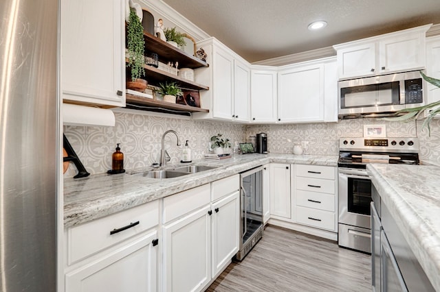 kitchen featuring open shelves, wine cooler, recessed lighting, a sink, and appliances with stainless steel finishes