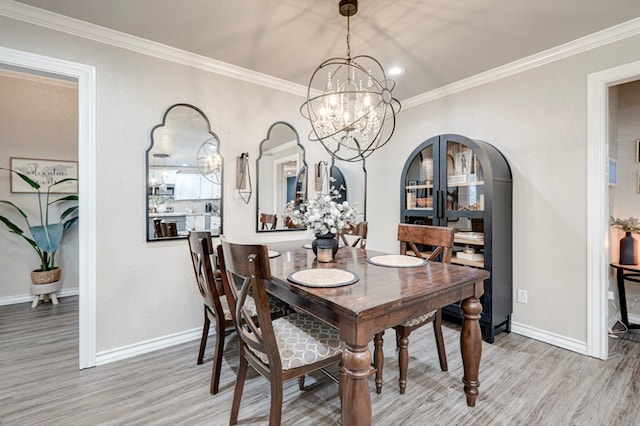 dining space with light wood-style floors, arched walkways, ornamental molding, and a chandelier